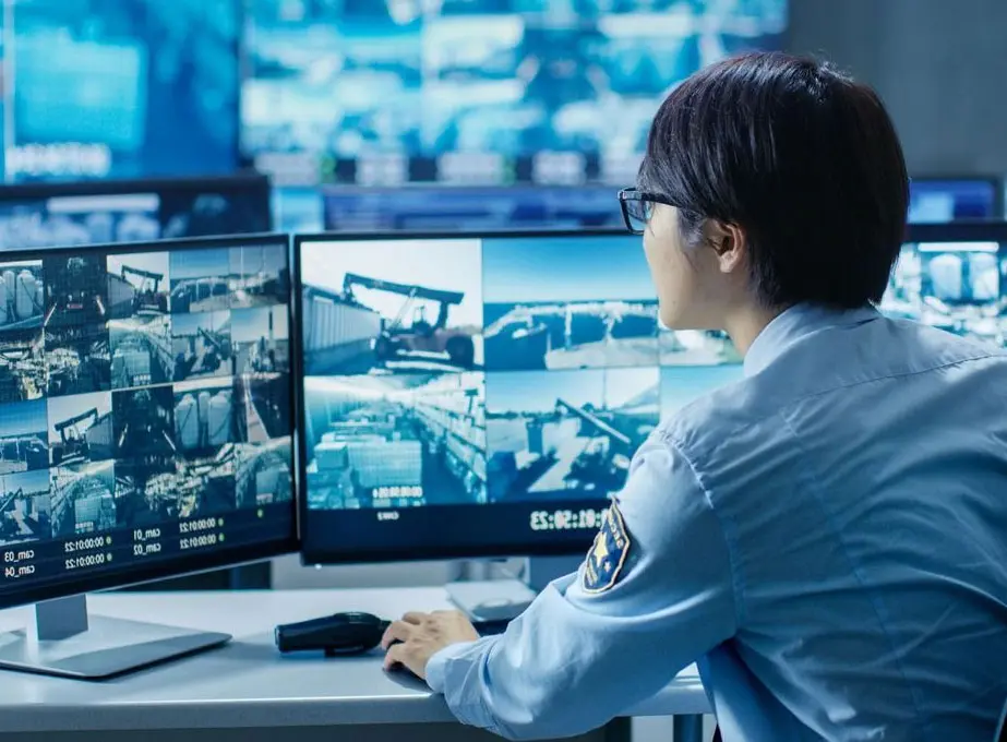 A security guard is sitting at his desk